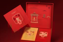 Luxurious Cartier Lunar New Year gift set featuring red and gold red packets with little panther motifs, traditional Chinese architecture, and festive design elements, perfect for celebrating the Chinese New Year.